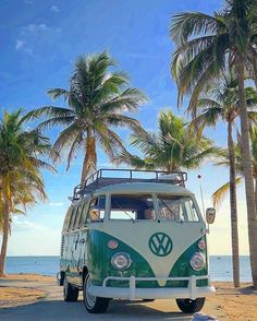 a vw bus parked on the beach with palm trees