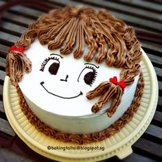 a white cake with brown icing and a smiling face on it's side