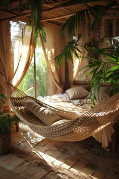 a hammock hanging from the ceiling in a room with plants and pillows on it