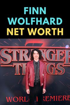 a man standing on top of a red carpet in front of a sign that says, finn wolfhard net worth