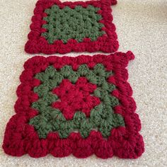 two red and green crocheted squares on the floor