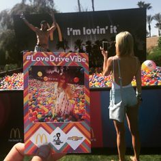 a person holding up a mcdonald's love drive - vibe card in front of a carnival