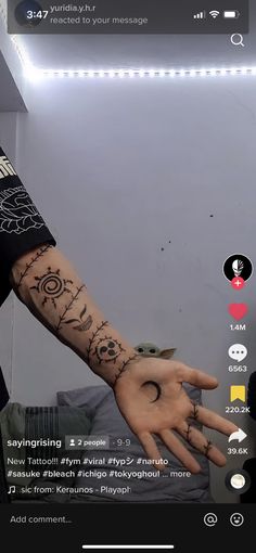 a person with a tattoo on their arm and hand in front of the camera screen