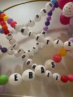 some balloons and letters are hanging from the ceiling