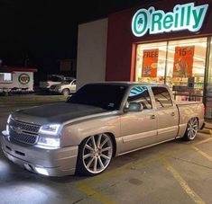 a silver truck parked in front of a store