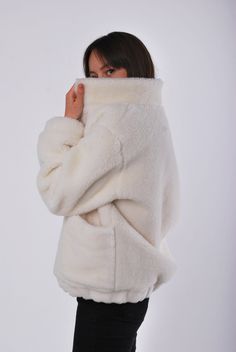 "Fashionable short fur coat made of 100% merino wool is an excellent option for outerwear both for every day and for any festive event. This model looks great with jeans, trousers, and with a dress or skirt. The fur coat is made in the \"oversize\" style, with a stand-up collar, which is very convenient, because it completely covers the neck and you do not need a scarf! Fastens with invisible buttons , large patch pockets. The lower part of the product and the sleeves with elastec , so the wind Cozy Beige Turtleneck Outerwear, White Oversized Turtleneck Outerwear, Oversized Fur Coat With Faux Fur Lining, Cozy Long Sleeve Fur Coat With Pockets, Cozy Outerwear In Winter White With Soft Texture, Oversized Beige Fur Coat, White Long Sleeve Outerwear With Soft Texture, Cozy Fur Coat With Faux Fur Lining, Winter White Outerwear For Loungewear