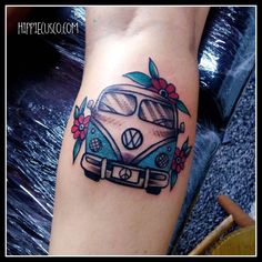 a tattoo on the arm of a woman with a vw camper van and flowers