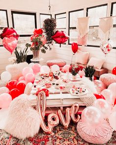 a room filled with balloons and decorations on top of a carpeted floor next to windows