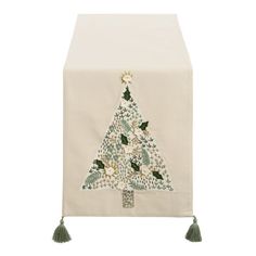 a white table runner with a christmas tree on the front and tassels at the bottom