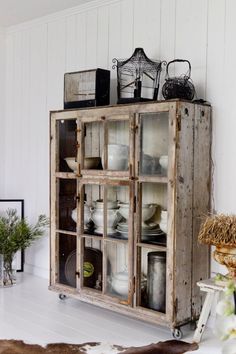 an old wooden cabinet is filled with dishes and vases on it's sides