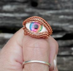 This eyeball ring has lifelike depth and has been wrapped in curvy copper wire.  This unique rainbow evil eye ring will catch compliments where ever you go and is sure to become your favorite piece of jewelry! This ring is perfect for the dark academia or cottagegore look.  I handcraft these rings myself, right here in the USA, and I love watching each eye come to life in the process.  I make them with beauty and durability in mind, if you have any questions at all, please get in touch! You will Eye Ring Diy, Eye Rings Aesthetic, Eye Wire Ring, Googly Eye Rings, Eyeball Jewelry, Wire Wrapped Eye Pendant, Dark Academia Jewelry, Copper Eye, Evil Eye Ring