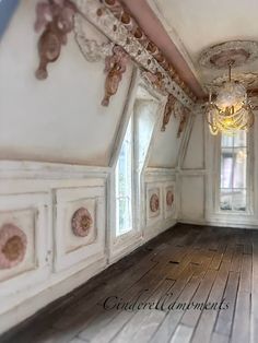 an empty room with white walls and wood floors, chandelier hanging from the ceiling