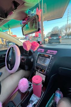 the interior of a car with pink pom - poms on the dash board