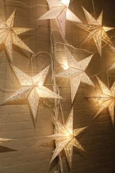 star lights hanging from the ceiling in front of a brick wall