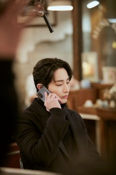 a woman sitting at a table talking on a cell phone