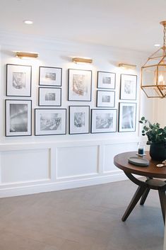 a dining room with pictures on the wall and a potted plant in front of it