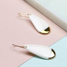 White earrings are handmade from porcelain and hand painted with 24 k gold luster. Perfect earrings to match your daily and occasion wear. Lightweight and very comfortable, you won't feel that you are wearing anything at all. Handmade 14 k gold-filled hooks are high quality - safe for most people with allergies and doesn't change colour after time. Minimalist jewelry that will add unusual detail to your style. Unique design earrings and great idea for gift. More designs avaliable: https://www.et Everyday Single Enamel Earring, Handmade White Enamel Earrings, White Modern Drop Earrings, Modern White Drop Earrings, Minimalist White Teardrop Earrings, Modern Gold Earrings With Enamel, Modern Gold Enamel Earrings, Everyday Gold Enamel Earrings, White Minimalist Teardrop Dangle Earrings