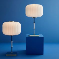 two lamps sitting on top of a blue table