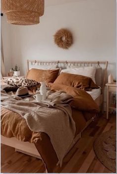 a bed sitting in a bedroom next to a lamp and pillows on top of a wooden floor