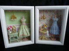 two framed pictures of dresses and shoes in a room with floral wallpaper, one has a doll's dress on the table