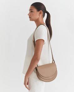 Our sculptural Double Moon Saddle Bag is crafted with practical details of two compartments, a back slip pocket, an easy magnetic closure, and an adjustable strap for crossbody and shoulder carrying. | Made in Turkey from soft and supple leather with a pebbled texture. Our luxurious leather wears well over time and only gets better with age. | Leather Working Group is the world's leading environmental certification for the leather industry. It affirms that our leather is tanned in an environment Timeless Everyday Saddle Bag With Detachable Handle, Modern Everyday Luxury Crossbody Shoulder Bag, Timeless Everyday Saddle Bag With Removable Pouch, Chic Everyday Luxury Crossbody Satchel, Luxury Saddle Bag Satchel For On-the-go, Chic Saddle Bag With Adjustable Strap, Chic Saddle Bag For Daily Use, Chic Saddle Bag With Gold-tone Hardware For Travel, Everyday Saddle Bag With Detachable Strap