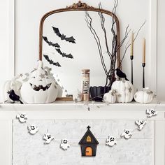 a mantle decorated with halloween decorations and candles