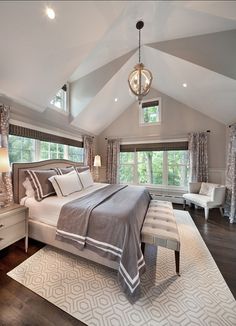 a large bed sitting in the middle of a bedroom on top of a hard wood floor