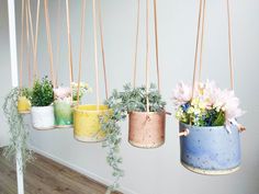 four hanging planters with flowers in them