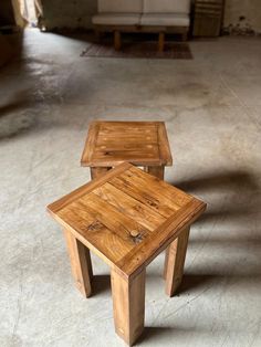 two wooden stools sitting on top of a cement floor next to each other in a room