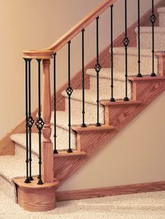 a stair case with wrought iron railing and wood handrails