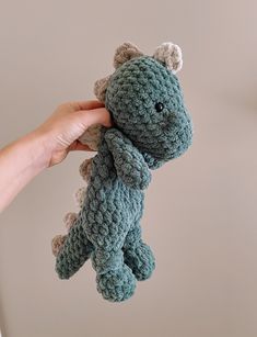 a hand holding a small crocheted stuffed animal