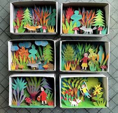 four boxes filled with different types of paper cut out animals and people in the woods