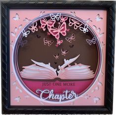 a pink and black frame with an open book in the center that says just one more charter