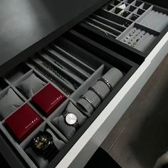 an open drawer with watches and bracelets on it's sides in a room