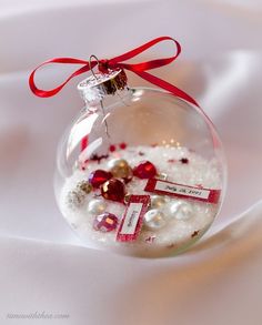 a glass ornament filled with white and red ornaments