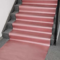 a pink carpeted staircase leading up to a door