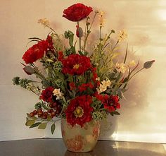 a vase filled with lots of red and white flowers