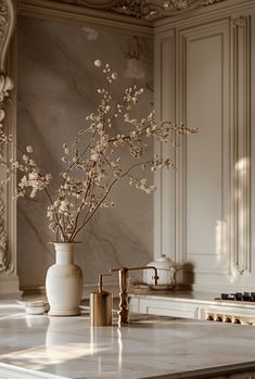 a vase filled with flowers sitting on top of a kitchen counter