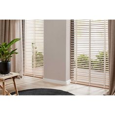 a living room filled with furniture and windows covered in wooden slatted blindes