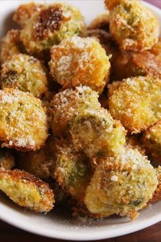 a white bowl filled with fried food on top of a wooden table