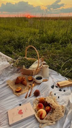 an image of a picnic setting on the grass with fruit and bread in front of it