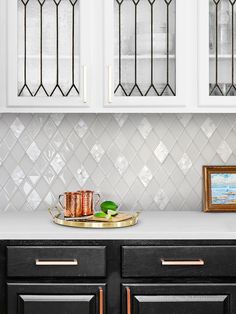 a black and white kitchen with gold trim on the cabinet doors, glass windows over the stove