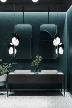 a bathroom with two sinks and three lights hanging from the ceiling over it's mirror