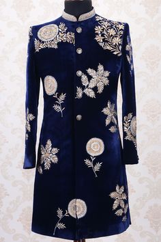 a blue velvet coat with gold and white flowers on it