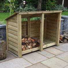 a wooden shed with logs stacked in the front and side by side on a patio