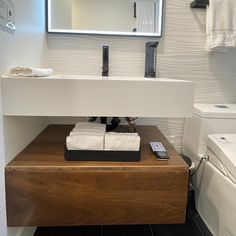 a bathroom with a sink, mirror and toilet paper roll on the counter in front of it