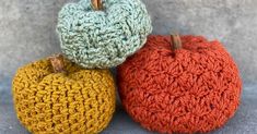 three crocheted pumpkins sitting next to each other