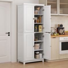 a kitchen with white cabinets and wooden floors