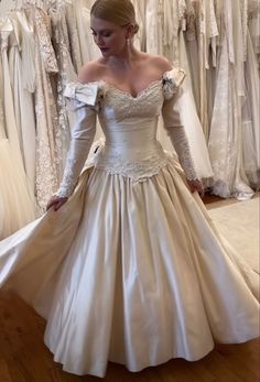 a woman in a wedding dress looking down at the floor