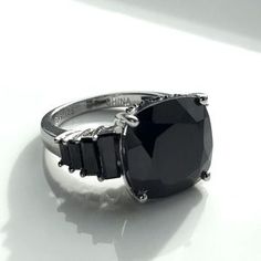 a black stone ring sitting on top of a white surface